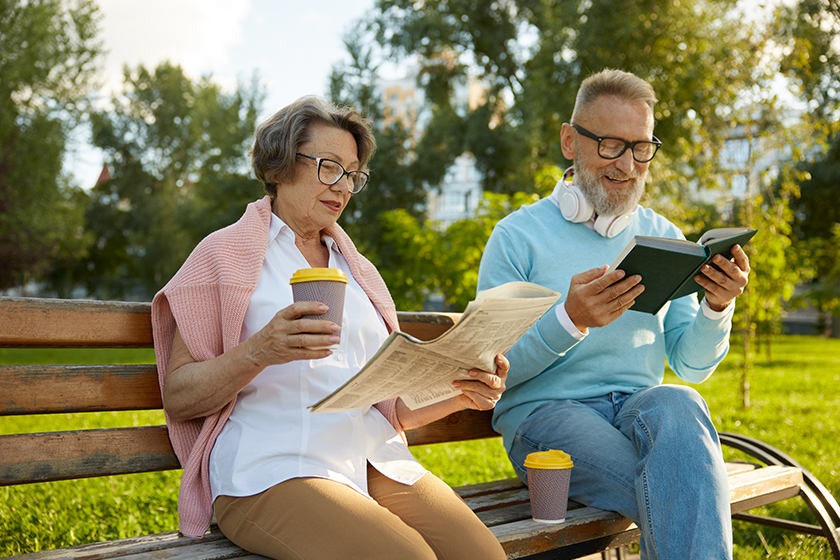 concentrated-man-woman-couple-reading-city-park-bench