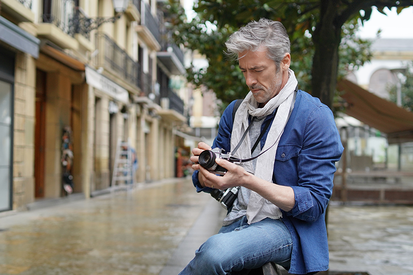 Mature photographer taking photos with vintage