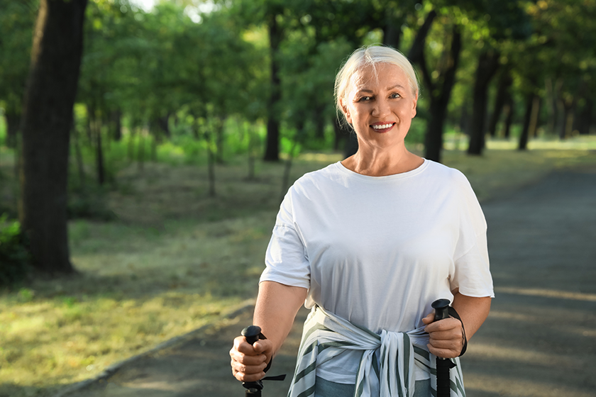 Mature woman with walking poles in park